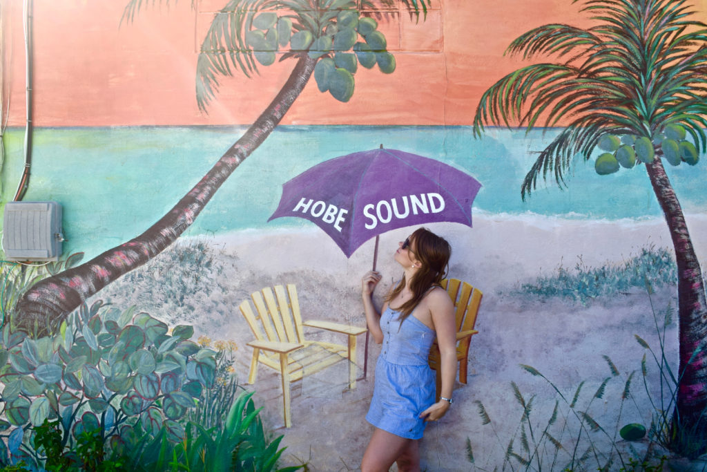 women in front of a mural of a beach