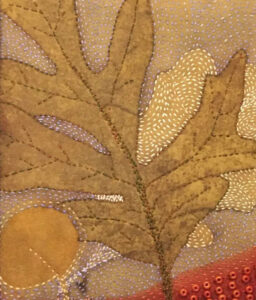 Textile artwork featuring a stylized, stitched leaf with surrounding patterns of dots and shapes in gold, brown, red, and white.
