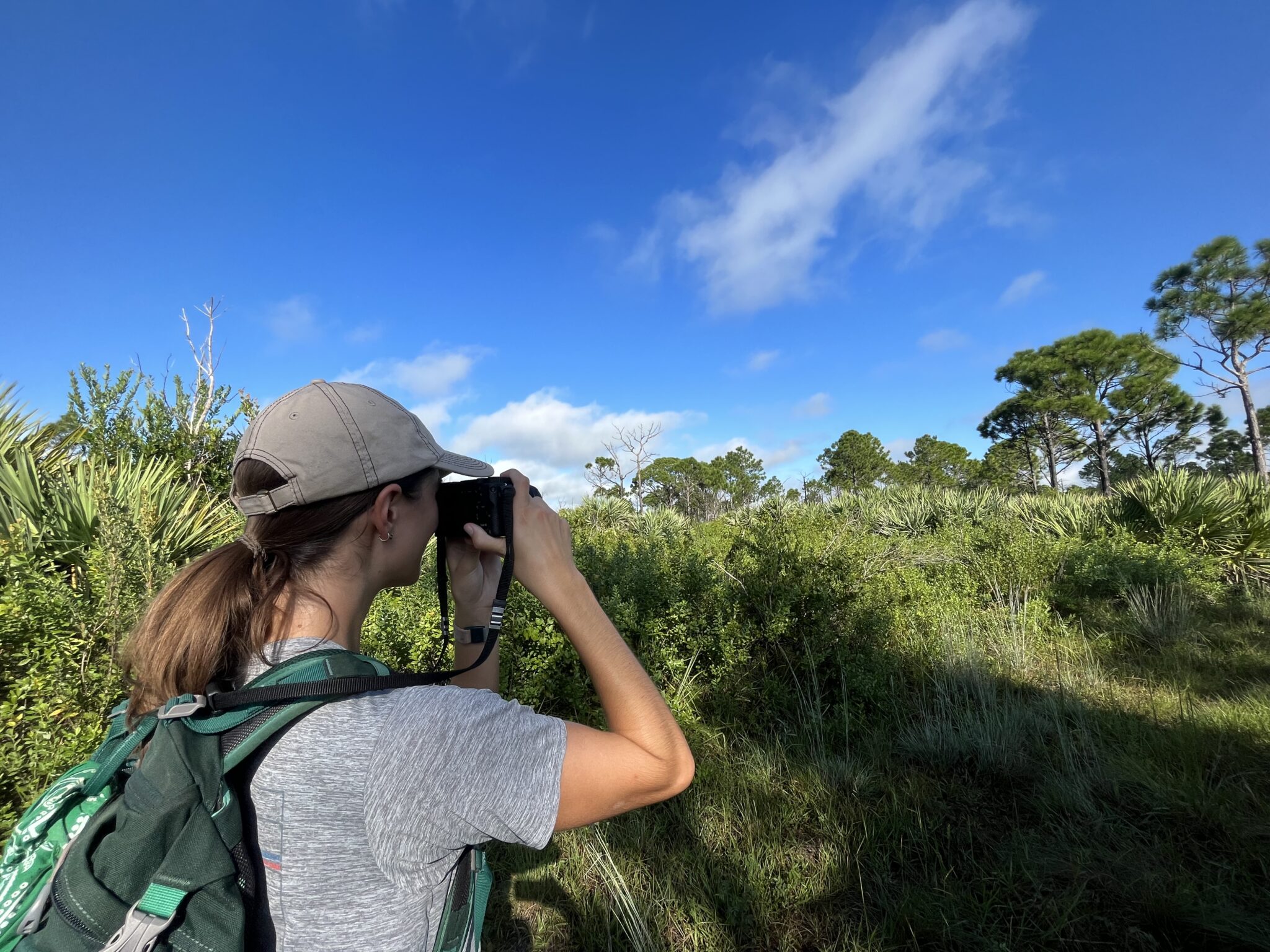 Women standing on beautiful green trail looking into binoculars