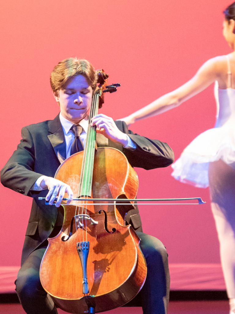cello performer on stage with ballerina