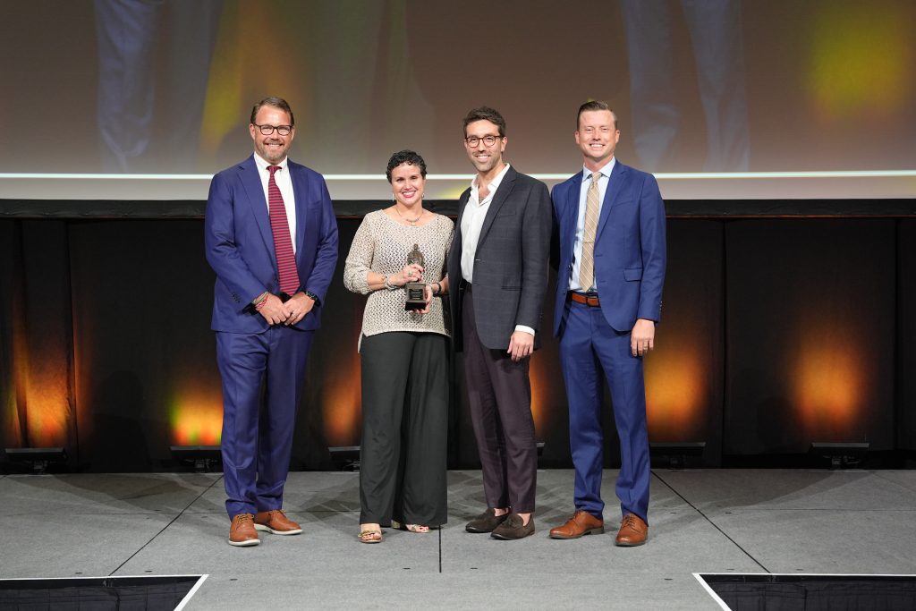 Bryan Giffin (CEO of Visit Florida) with Nerissa Okiye and Ian Centrone on stage accepting Flagler Award